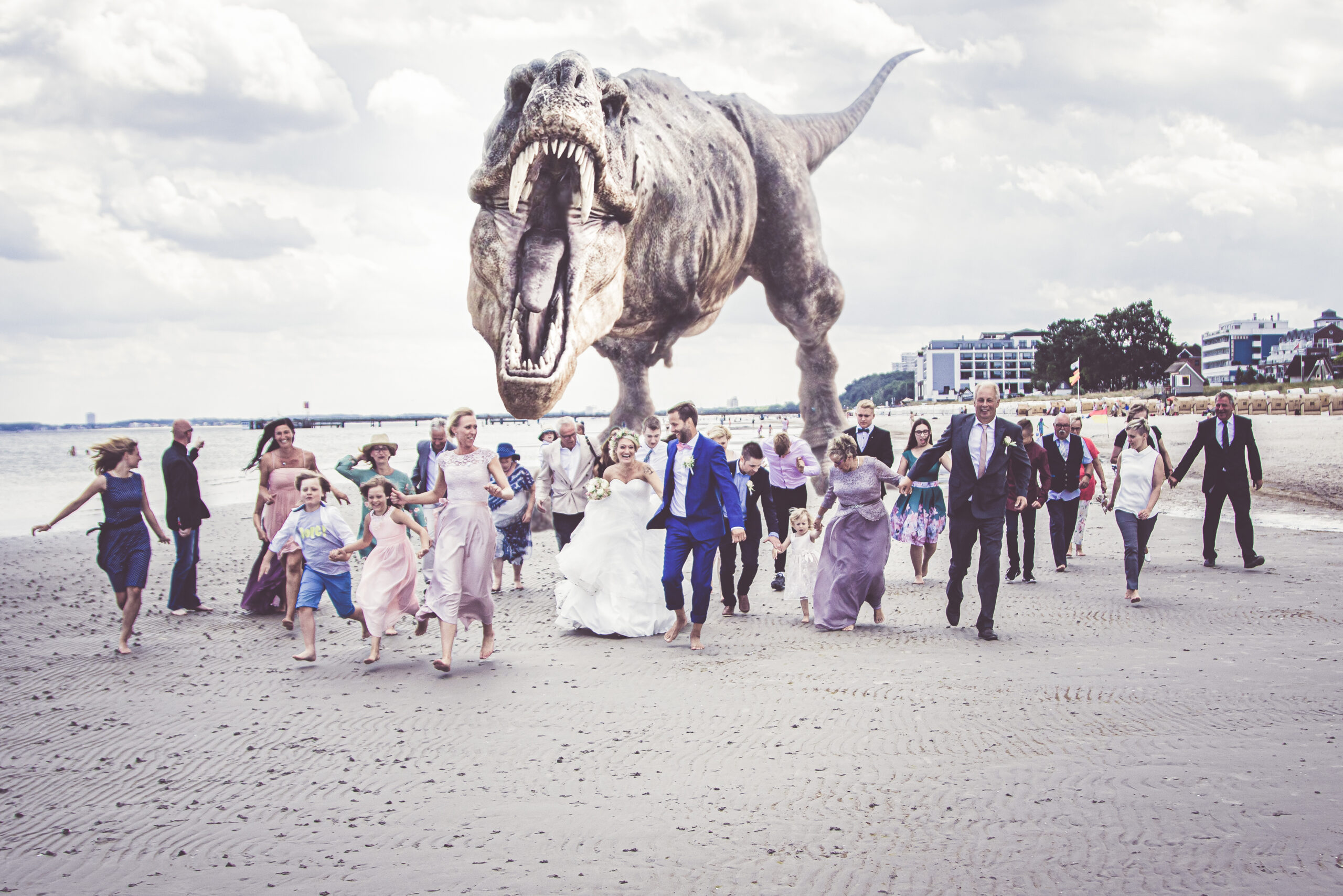 5B6A9476-Bearbeitet a group of people walking on a beach with a dinosaur