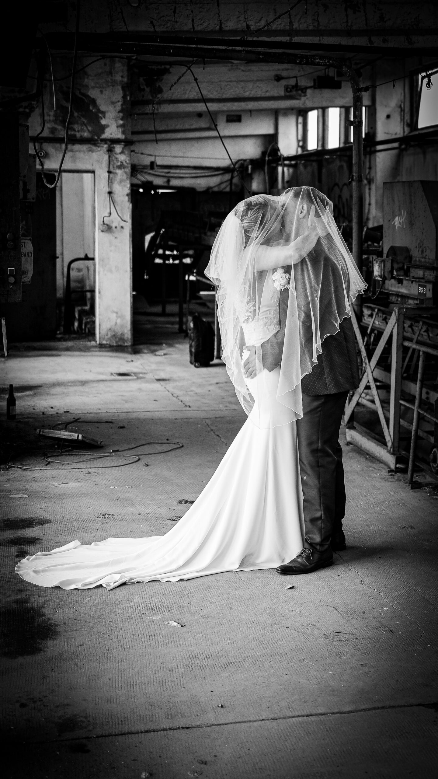 _54A9187 a man and woman kissing in a warehouse