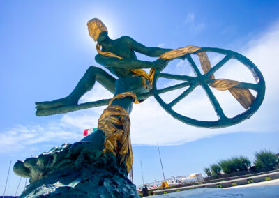 a statue of a man holding a wheel