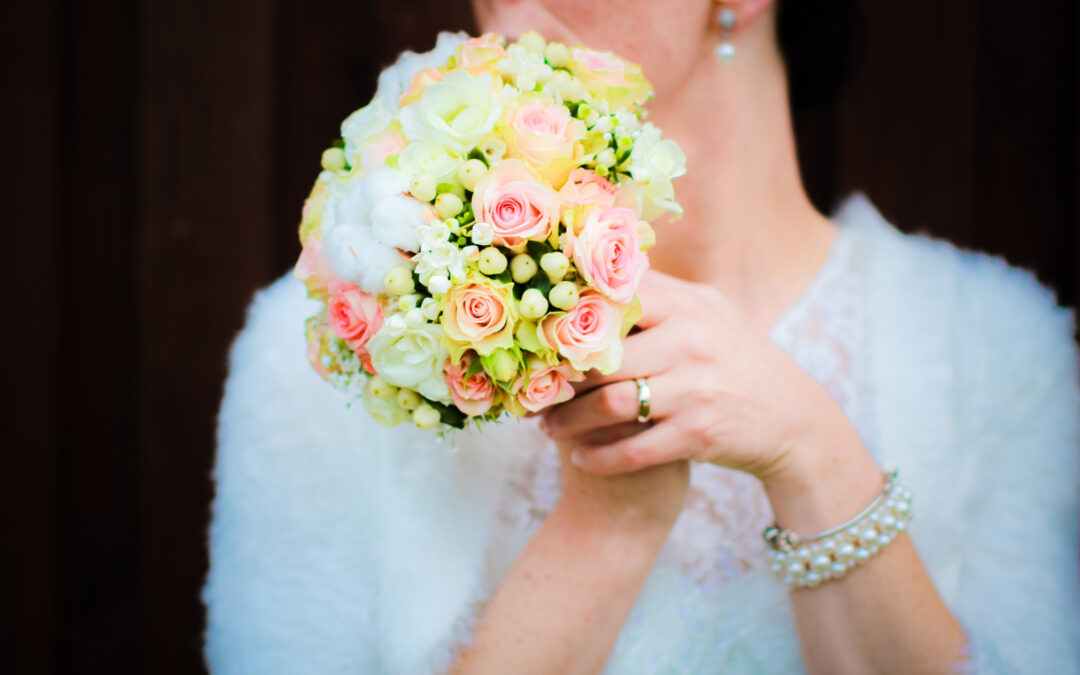 Braut hält einen farbenfrohen Blumenstrauß während ihrer Hochzeit – authentische und romantische Hochzeitsfotos.