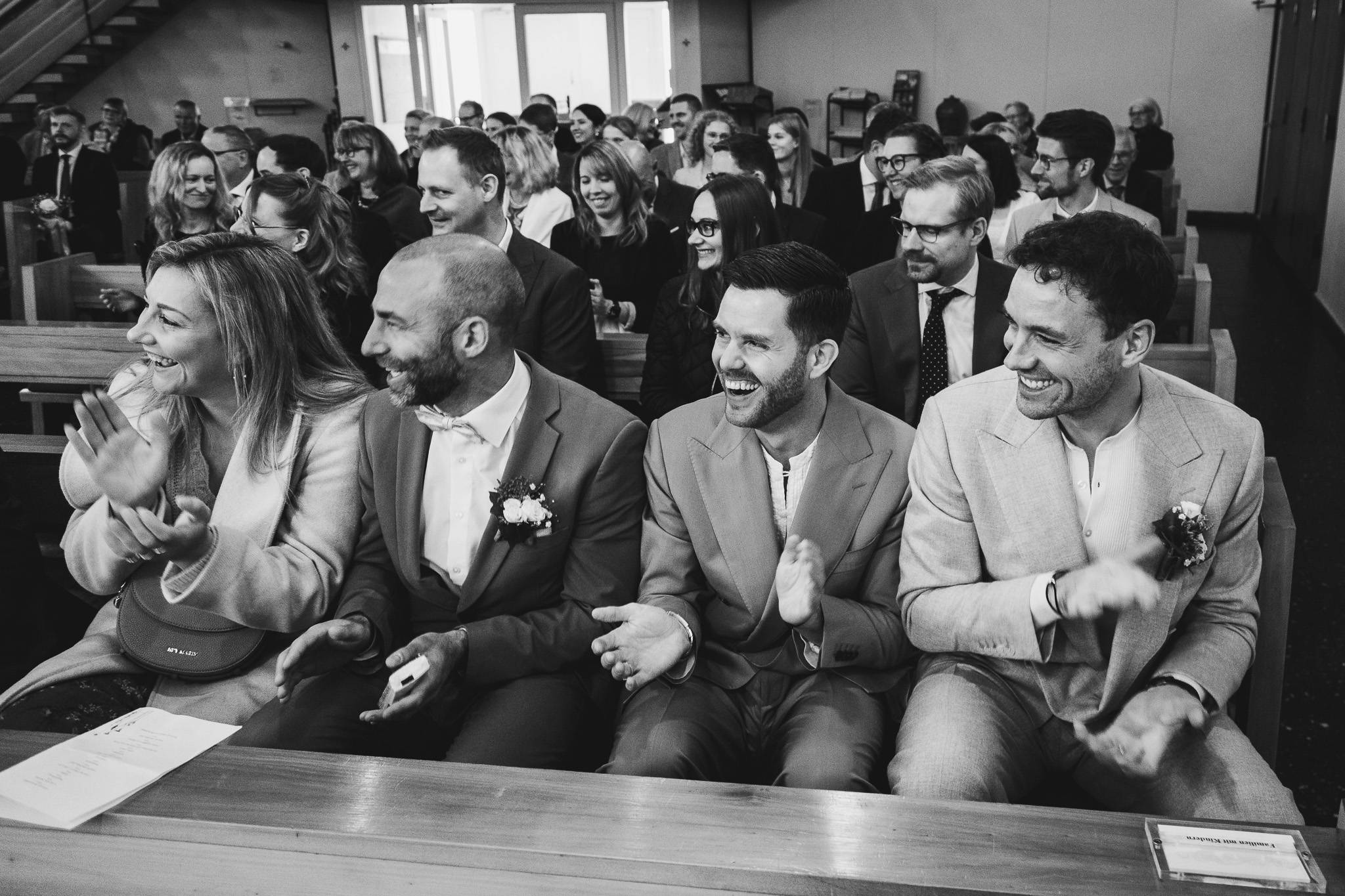 hochzeitsfotograf 2026 – emotionale Atmosphäre während der Trauung, applaudierende Gäste, schwarzweiß Reportage