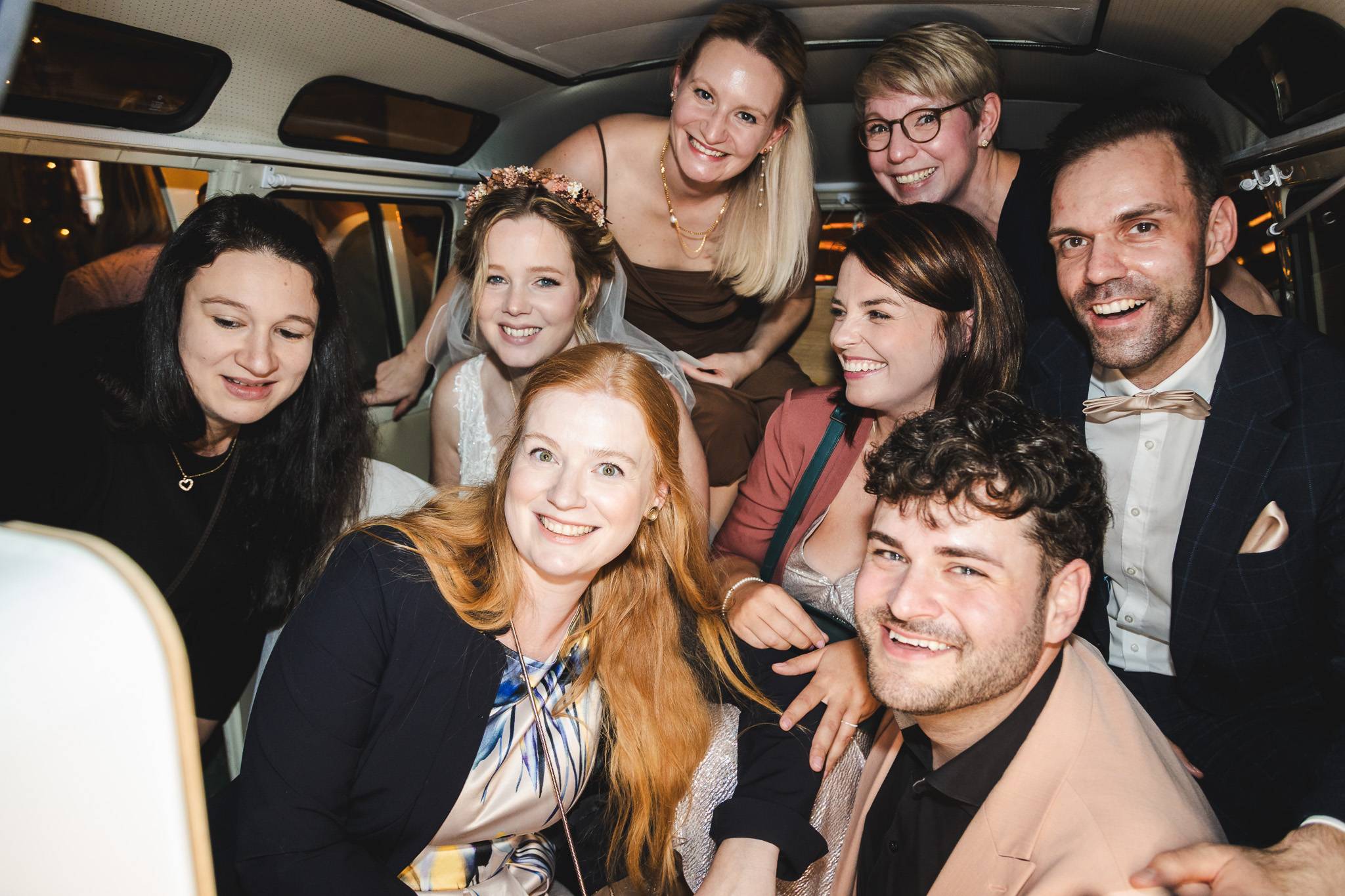 hochzeitsfotograf 2026 – ausgelassene Hochzeitsgesellschaft unterwegs im Bulli, echte Reportage und moderne Gruppenstimmung