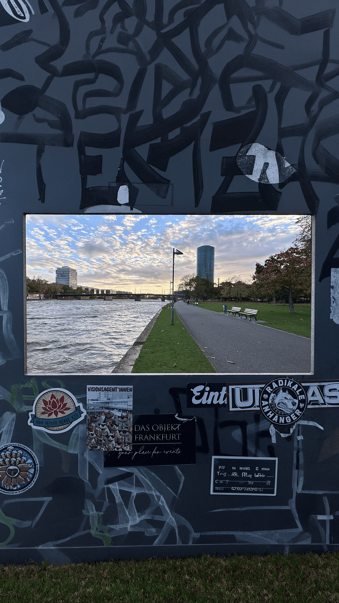 Frankfurter Mainufer durch einen Rahmen fotografiert bei Sonnenuntergang