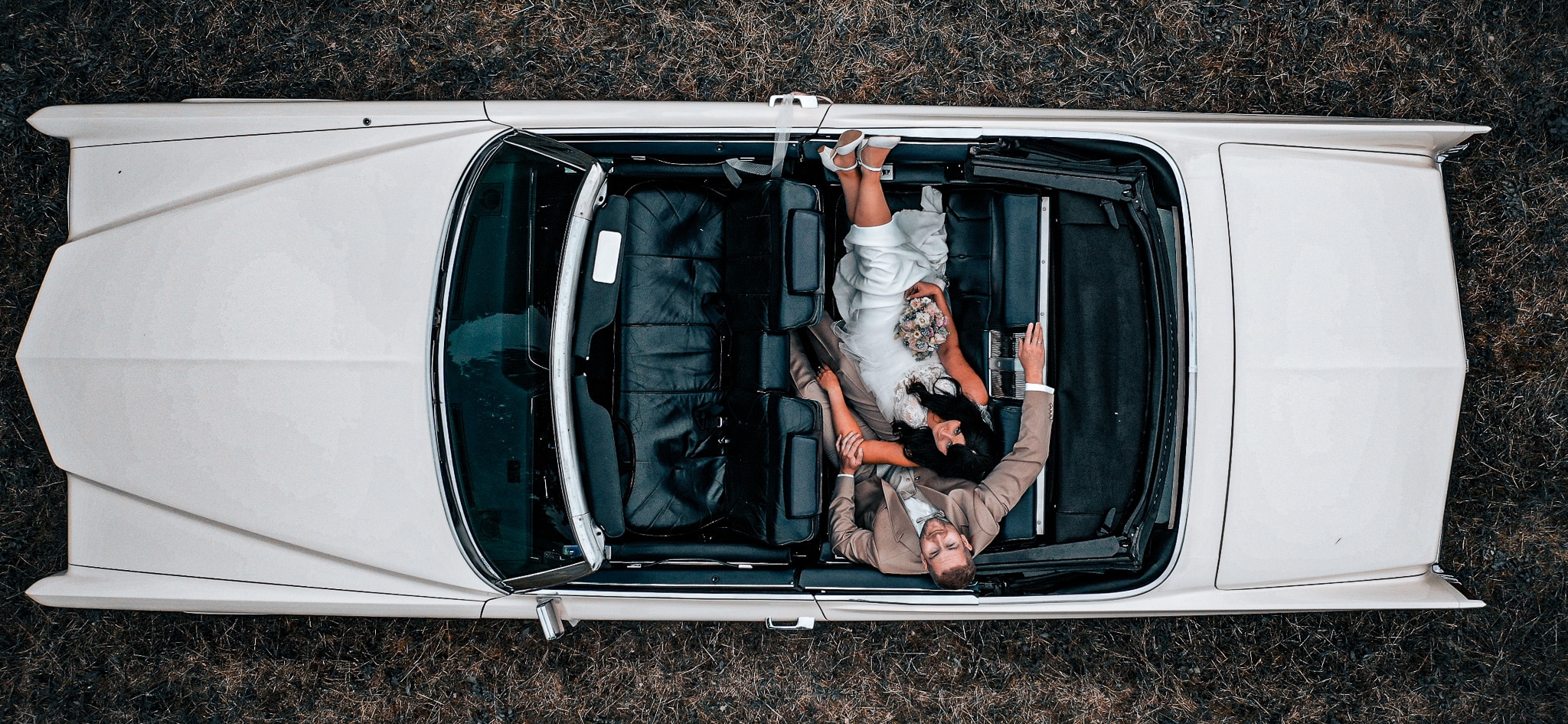 Hero-Image Hochzeitspaar in einem Oldtimer, bearbeitet
